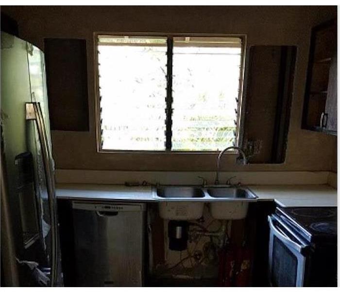 kitchen with sink, fridge, dishwasher and a window in the center