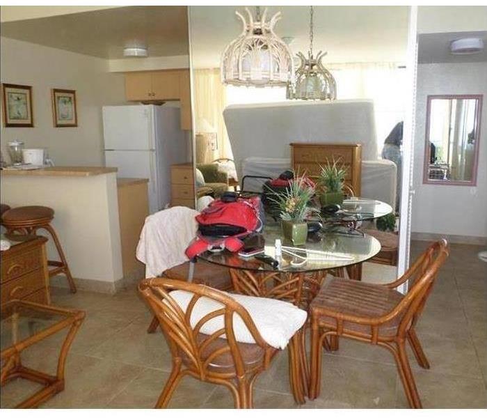 apartment interior with dining set and a kitchen in the background