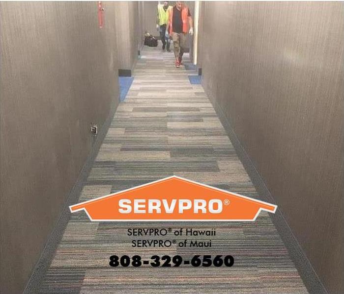 SERVPRO technicians are completing work to a water-damaged hallway after a flood. 